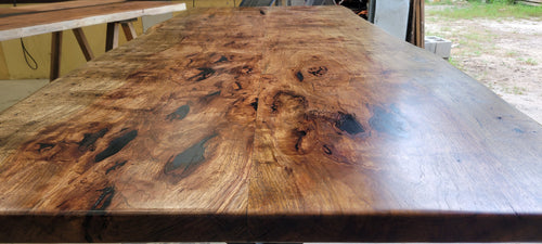 Pecan wood dining table with natural live edge slab top finished in Jacobean stain, handcrafted by Coleto Creek Mill & Design