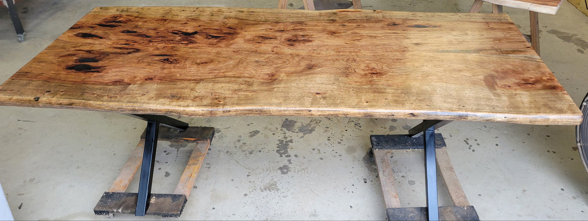 Pecan wood dining table with natural live edge slab top finished in Jacobean stain, handcrafted by Coleto Creek Mill & Design