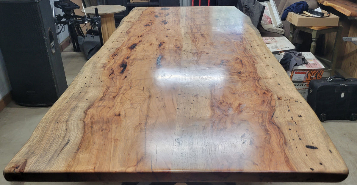 Handcrafted live edge pecan wood dining table featuring a natural edge slab top, unique wood grain, and custom metal legs