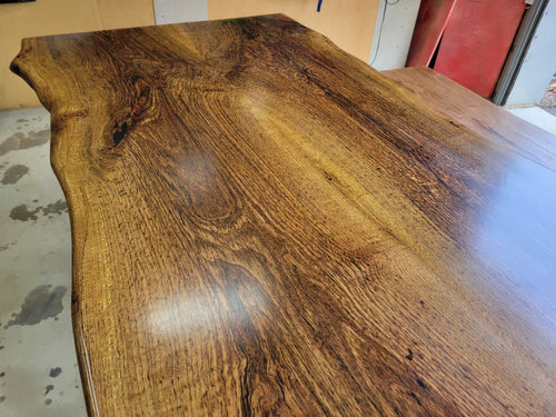 White oak dining table with a natural finish and black resin inclusions with matching bench 