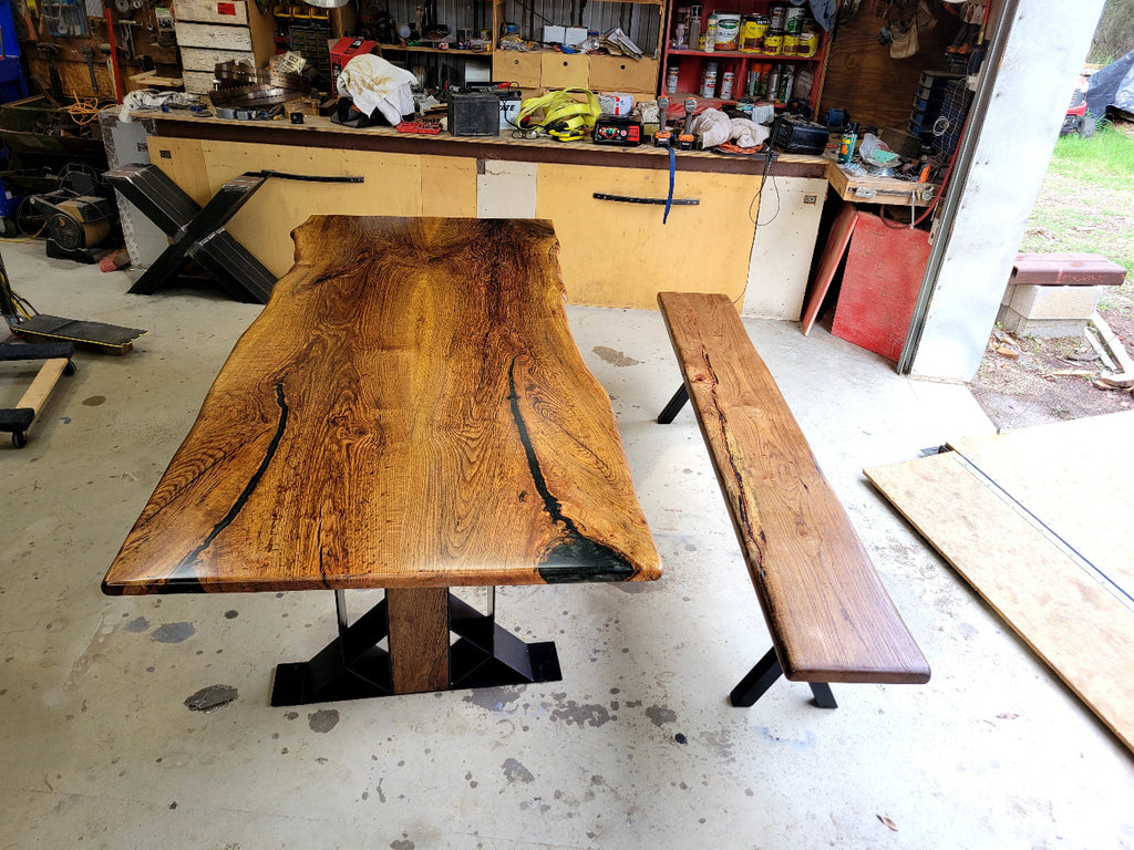 White oak dining table with a natural finish and black resin inclusions with matching bench 