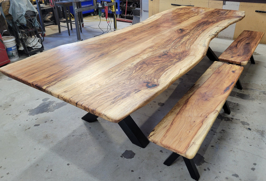 A large live-edge Pecan dining table with matching bench seats, in the natural color with x-style black metal legs