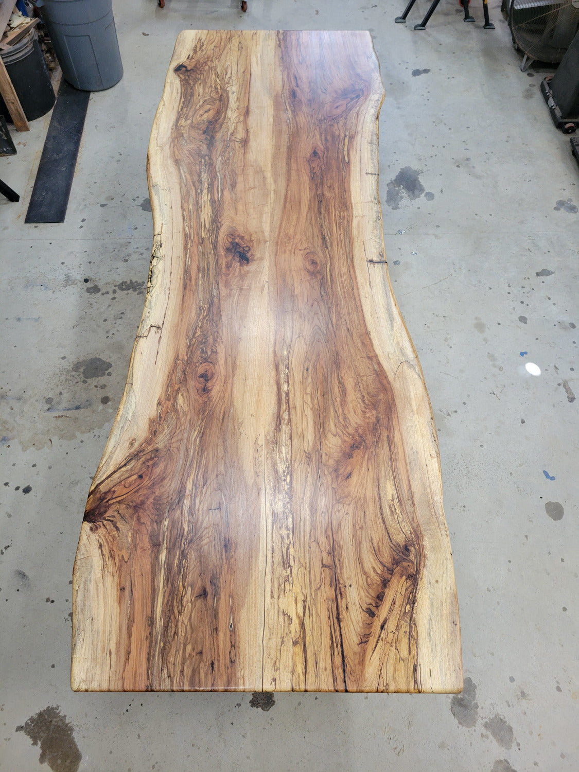 A large live-edge Pecan dining table with matching bench seats, in the natural color with x-style black metal legs