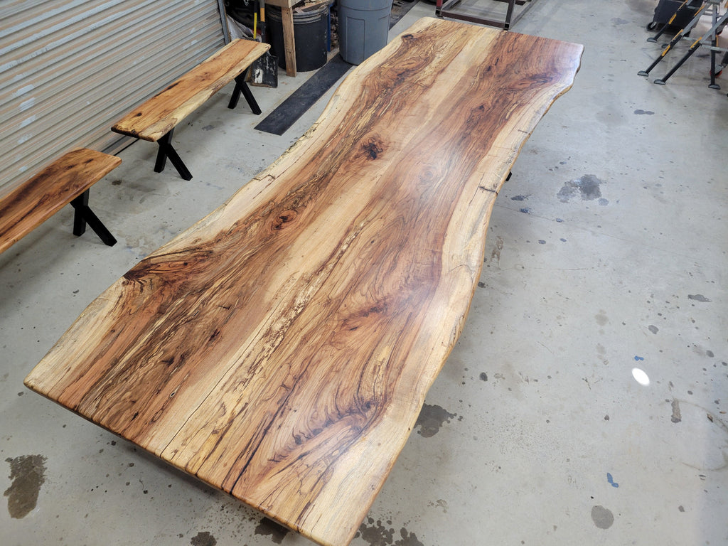 A large live-edge Pecan dining table with matching bench seats, in the natural color with x-style black metal legs