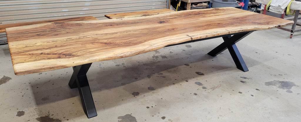 A large live-edge Pecan dining table with matching bench seats, in the natural color with x-style black metal legs