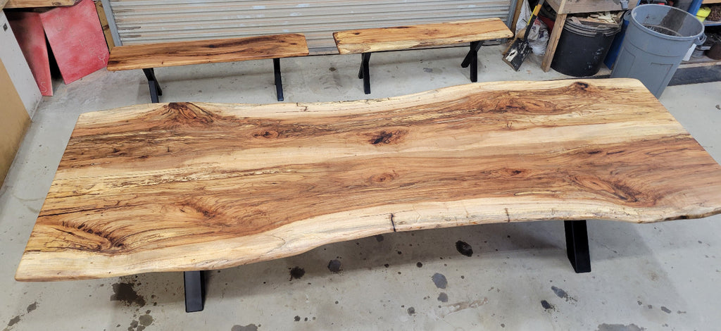 A large live-edge Pecan dining table with matching bench seats, in the natural color with x-style black metal legs