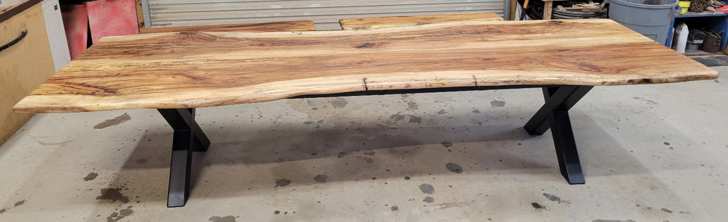 A large live-edge Pecan dining table with matching bench seats, in the natural color with x-style black metal legs