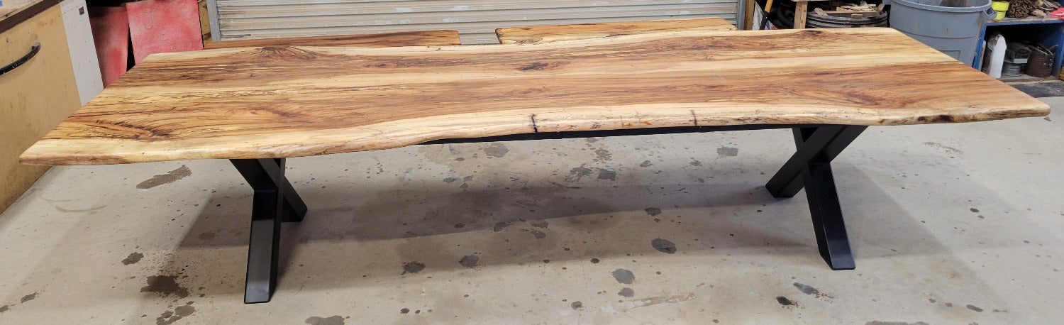 A large live-edge Pecan dining table with matching bench seats, in the natural color with x-style black metal legs