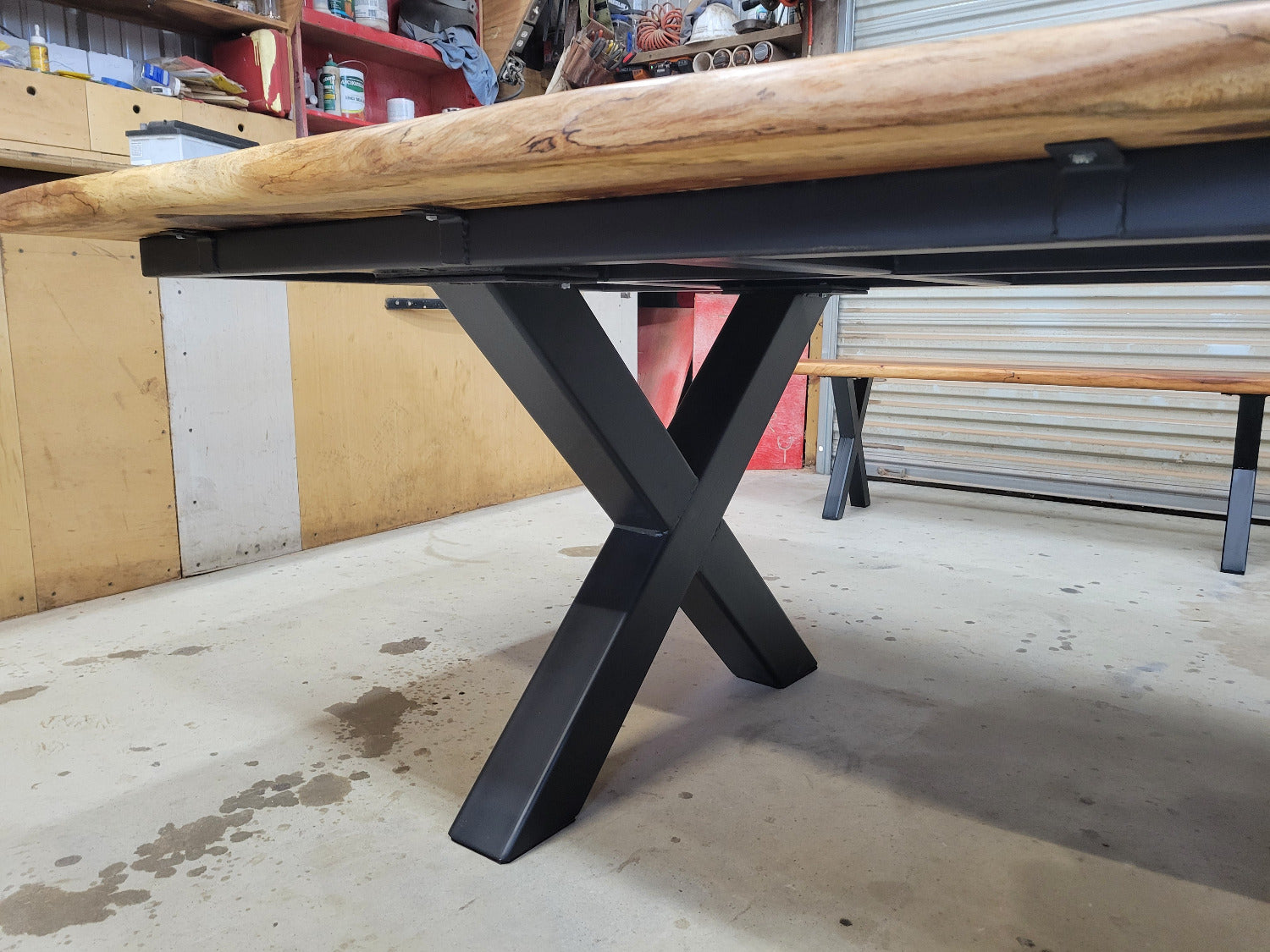 A large live-edge Pecan dining table with matching bench seats, in the natural color with x-style black metal legs