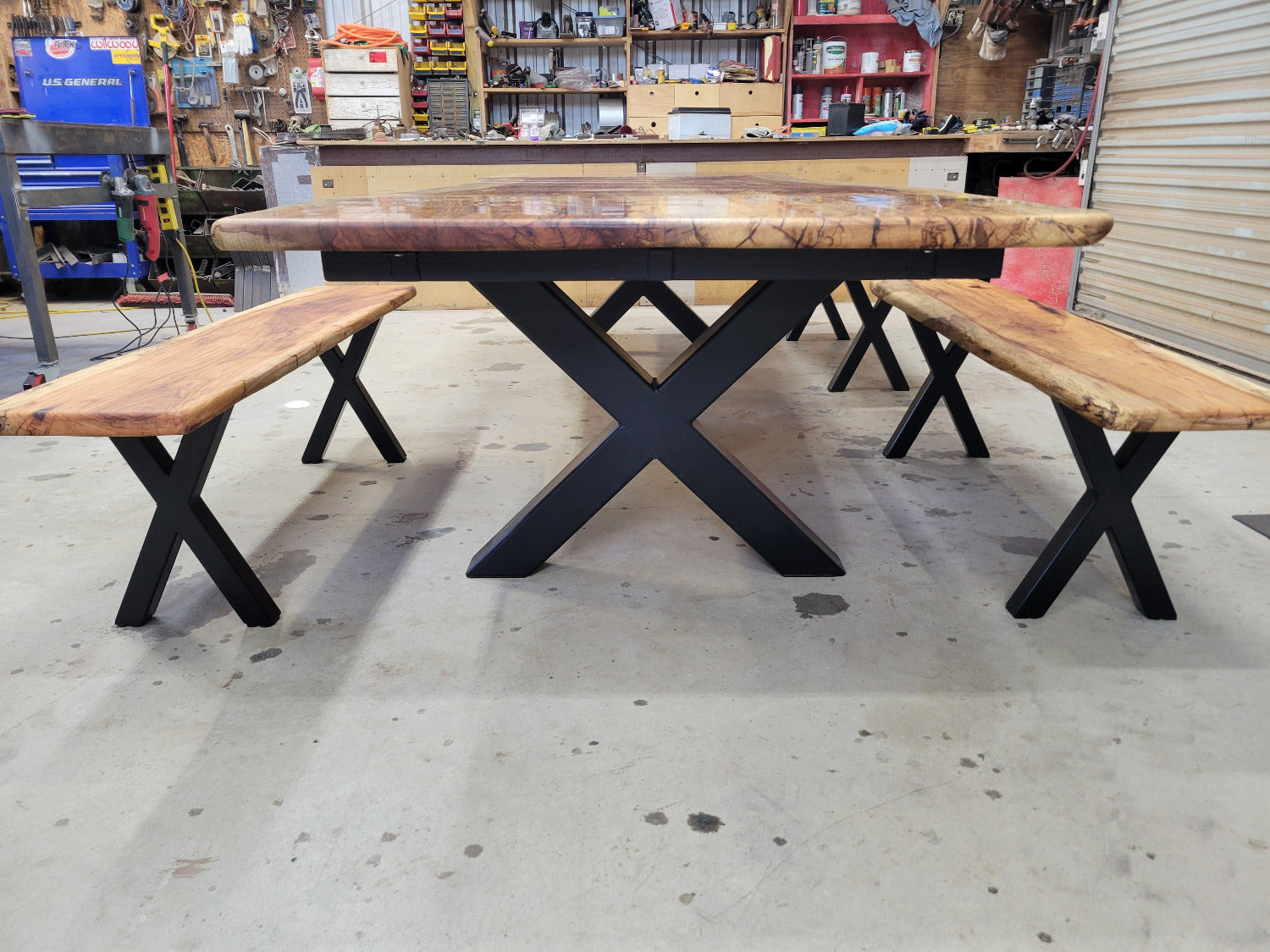 A large live-edge Pecan dining table with matching bench seats, in the natural color with x-style black metal legs