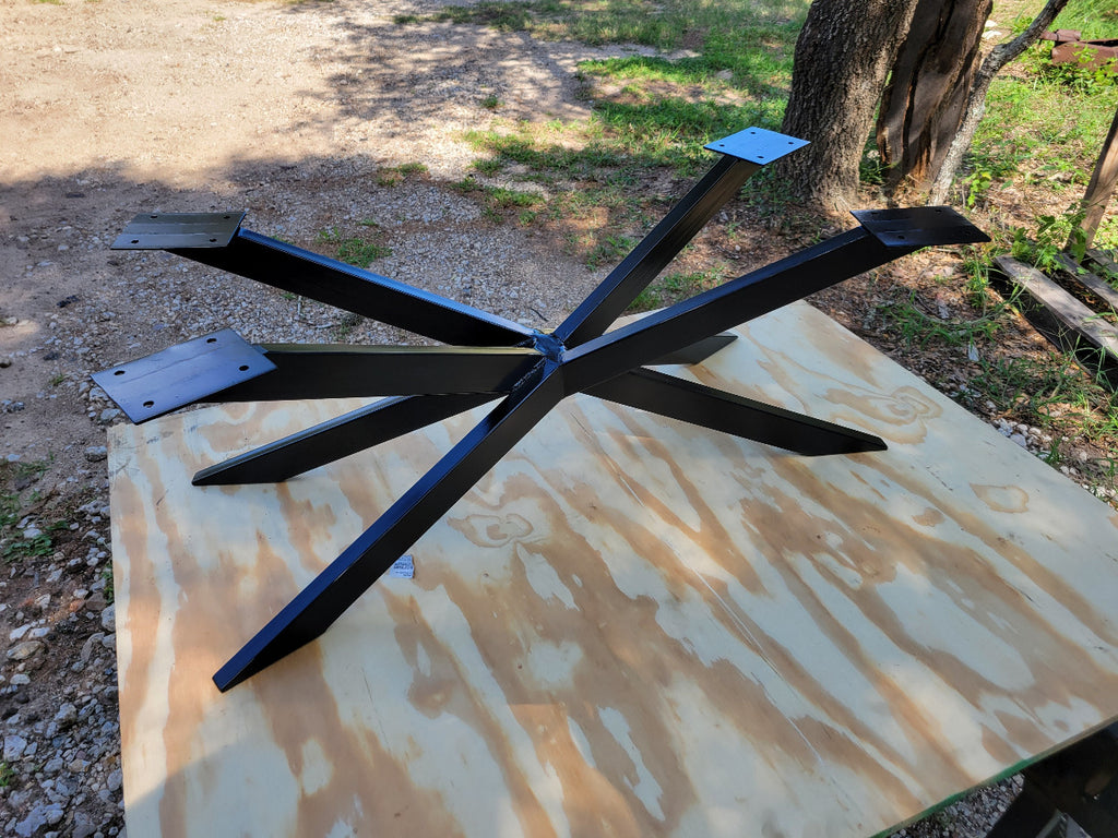Wooden double tree coffee table with a natural, rustic design and black metal cross style legs in a living room setting.