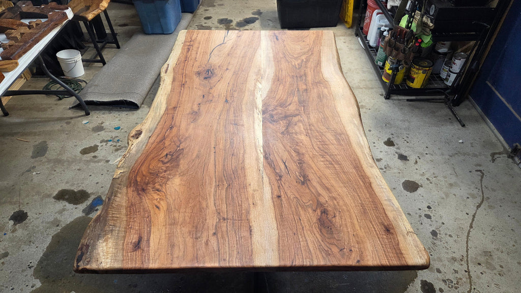 Live edge Pecan Breakfast table with black metal pedestal stand in natural color.