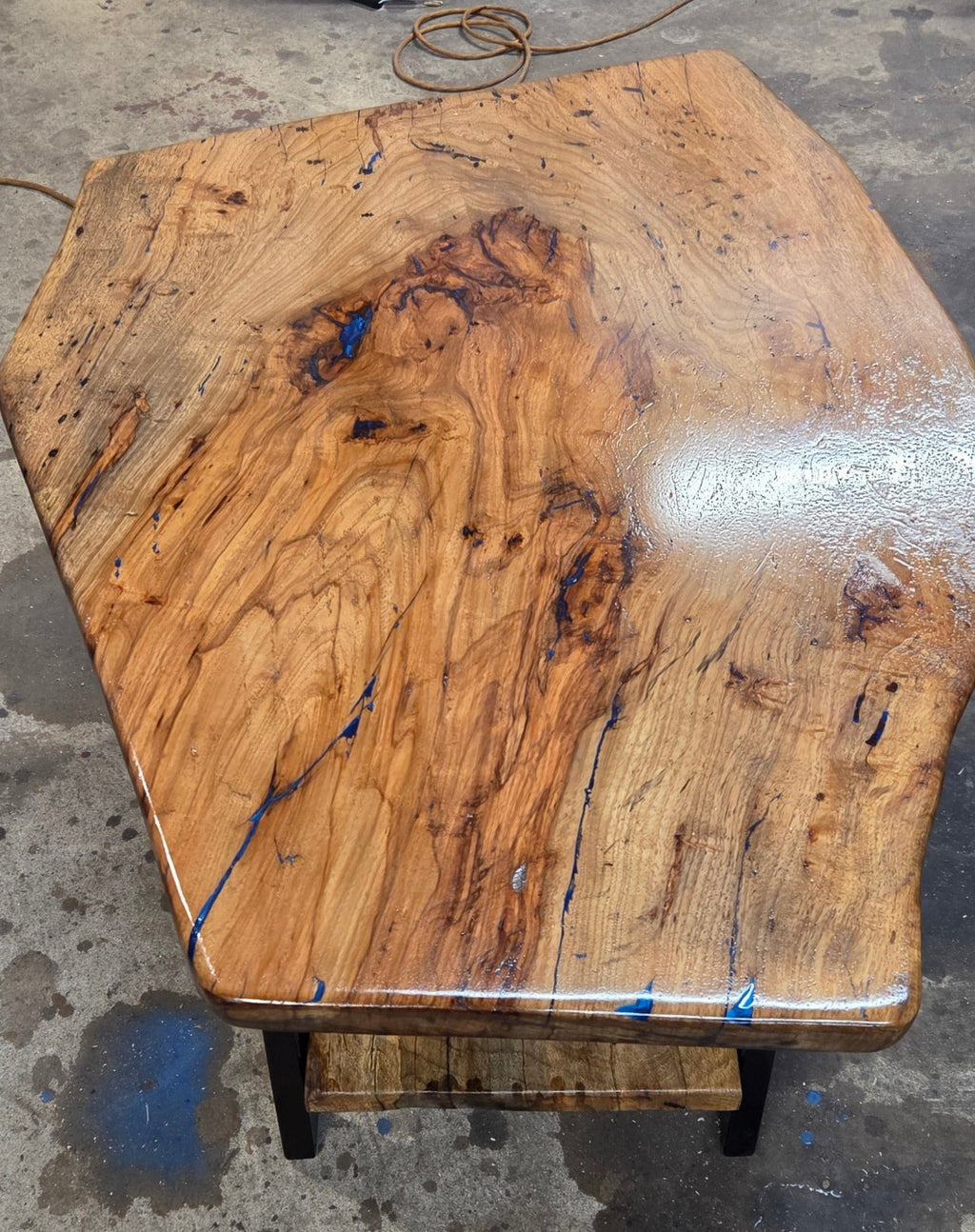 Live edge rustic Rectangular Pecan coffee table with lower shelf on black metal legs, blue epoxy inlay