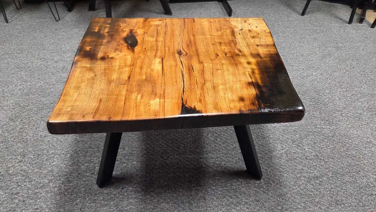 Pecan coffee table with a rustic finish and sho sugi bon treatment with black metal legs