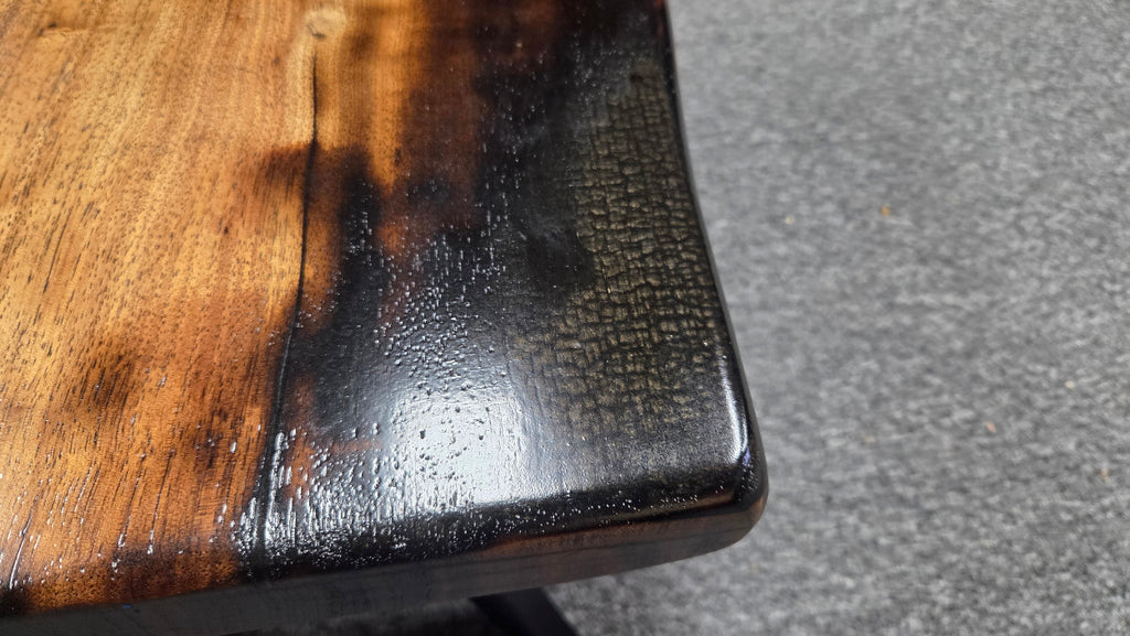Pecan coffee table with a rustic finish and sho sugi bon treatment with black metal legs