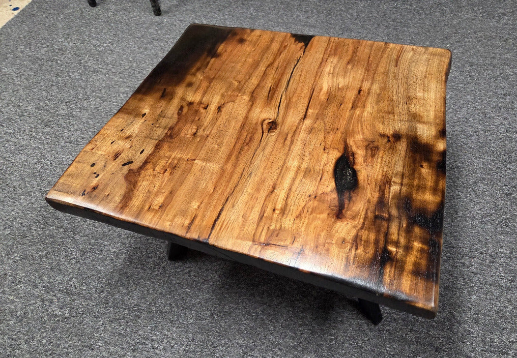 Pecan coffee table with a rustic finish and sho sugi bon treatment with black metal legs