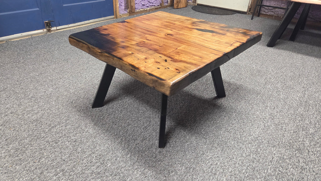 Pecan coffee table with a rustic finish and sho sugi bon treatment with black metal legs