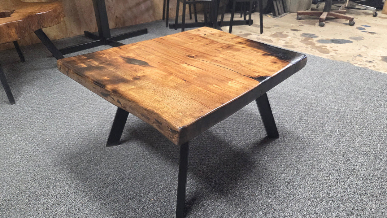 Pecan coffee table with a rustic finish and sho sugi bon treatment with black metal legs