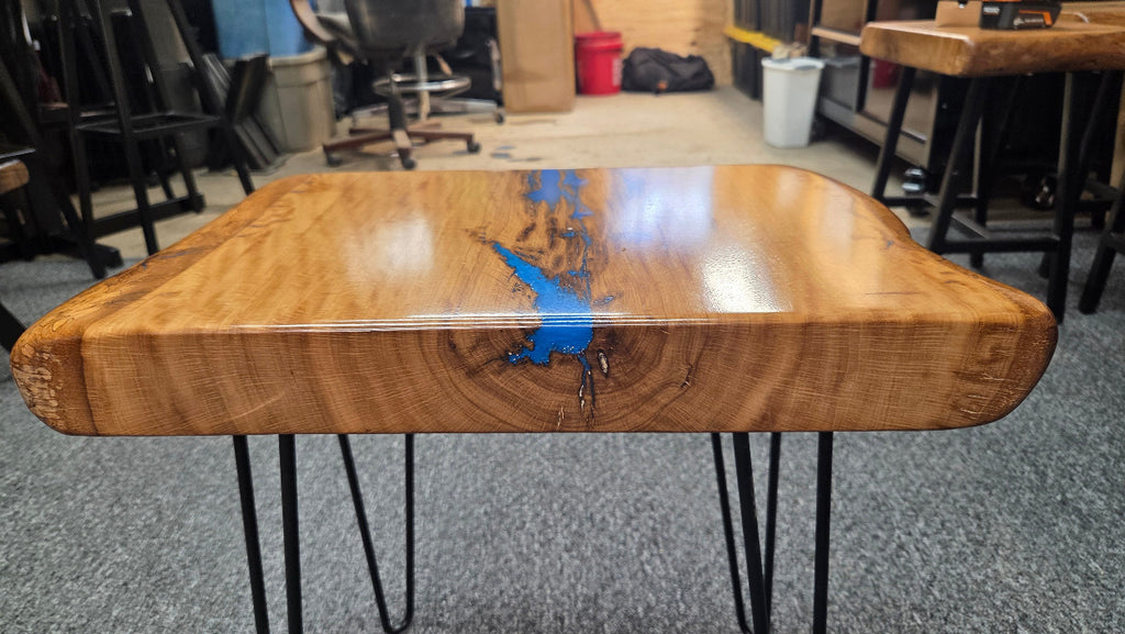 Live oak End table featuring live edge sides with blue epoxy inlay on black hair pin legs