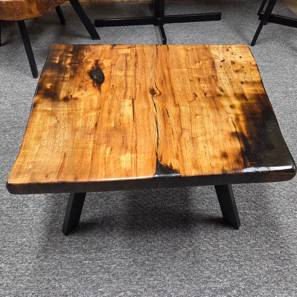Pecan coffee table with a rustic finish and sho sugi bon treatment with black metal legs
