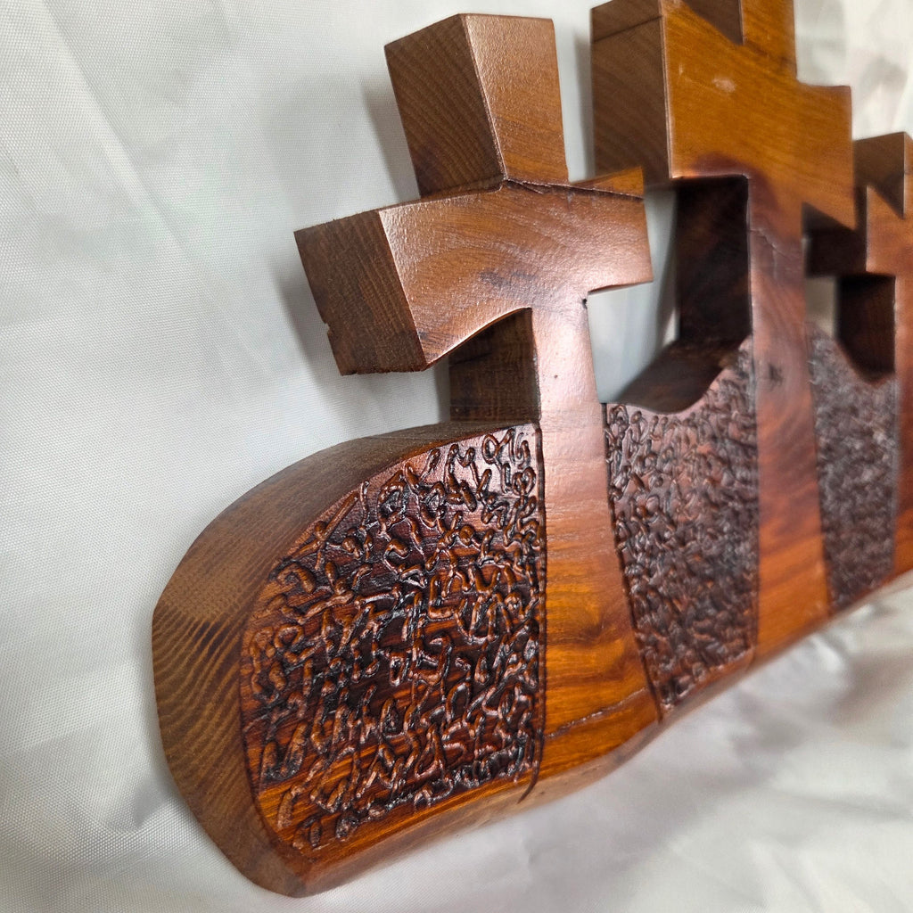 A Bois D'Arc decorative wall plaque featuring three stylized Christian crosses cut from a single slab, hand carved with burned finish sho sugi ban with natural grain 