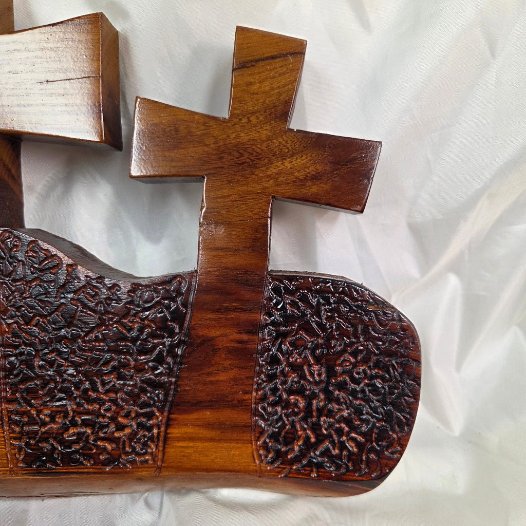 A Bois D'Arc decorative wall plaque featuring three stylized Christian crosses cut from a single slab, hand carved with burned finish sho sugi ban with natural grain 