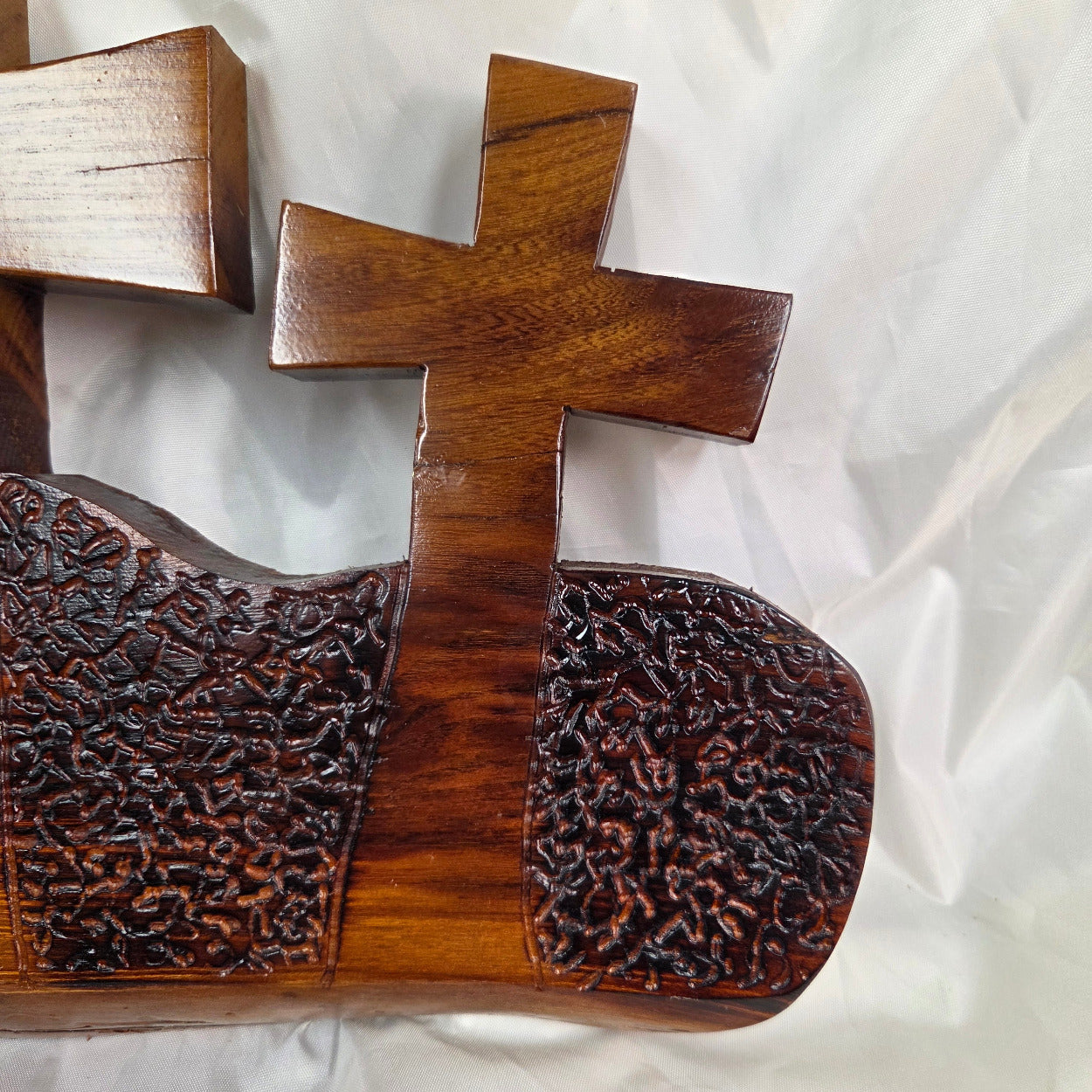 A Bois D'Arc decorative wall plaque featuring three stylized Christian crosses cut from a single slab, hand carved with burned finish sho sugi ban with natural grain 