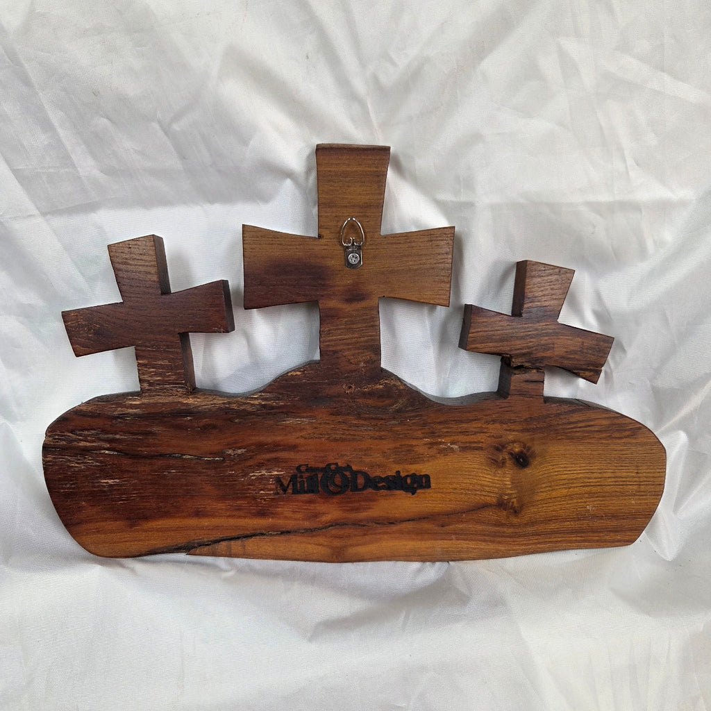 A Bois D'Arc decorative wall plaque featuring three stylized Christian crosses cut from a single slab, hand carved with burned finish sho sugi ban with natural grain 