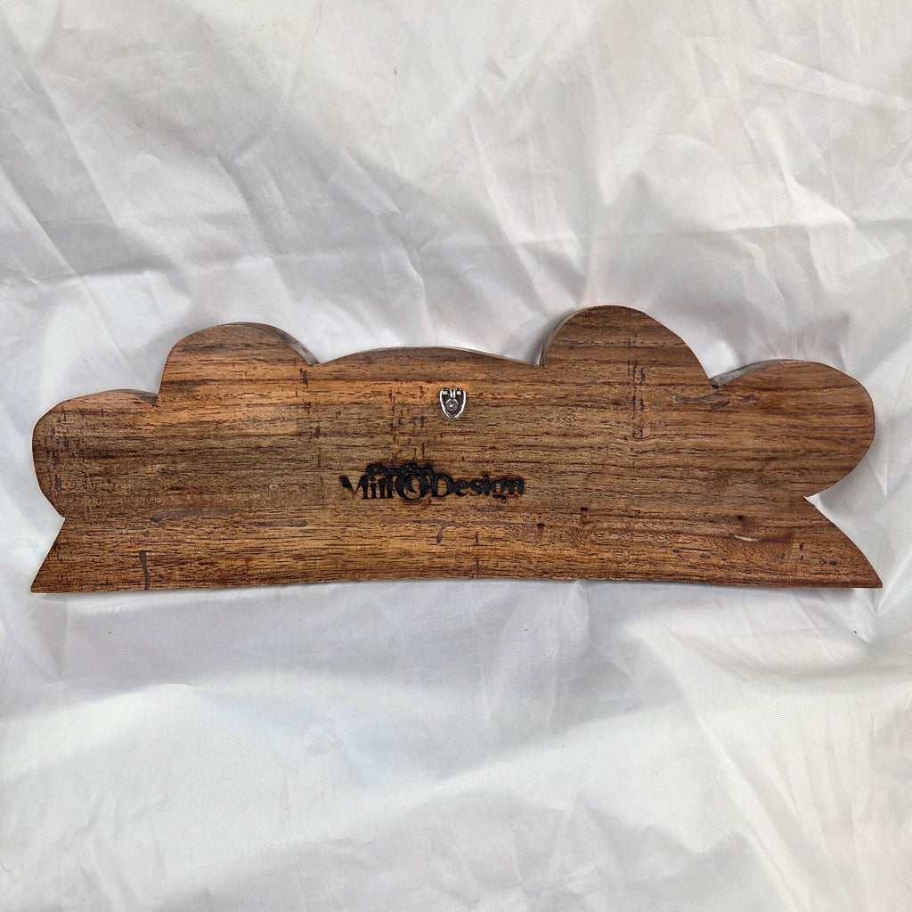 A rustic, handcrafted wooden plaque with a scalloped edge and a dark engraved brand name, displayed on a crumpled white background.