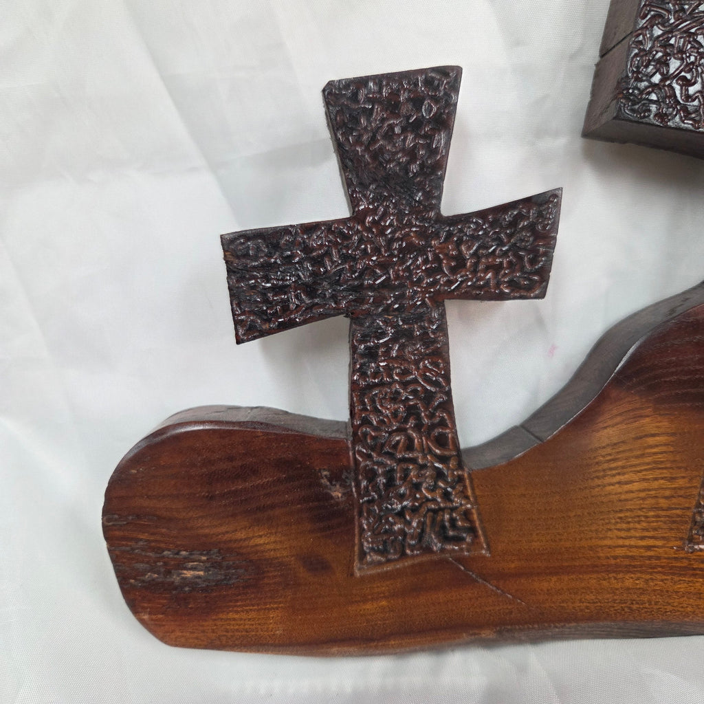 A Bois D'Arc decorative wall plaque featuring three stylized Christian crosses cut from a single slab, hand carved with burned finish sho sugi ban with natural grain 
