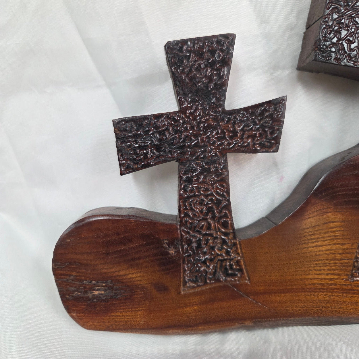 A Bois D'Arc decorative wall plaque featuring three stylized Christian crosses cut from a single slab, hand carved with burned finish sho sugi ban with natural grain 