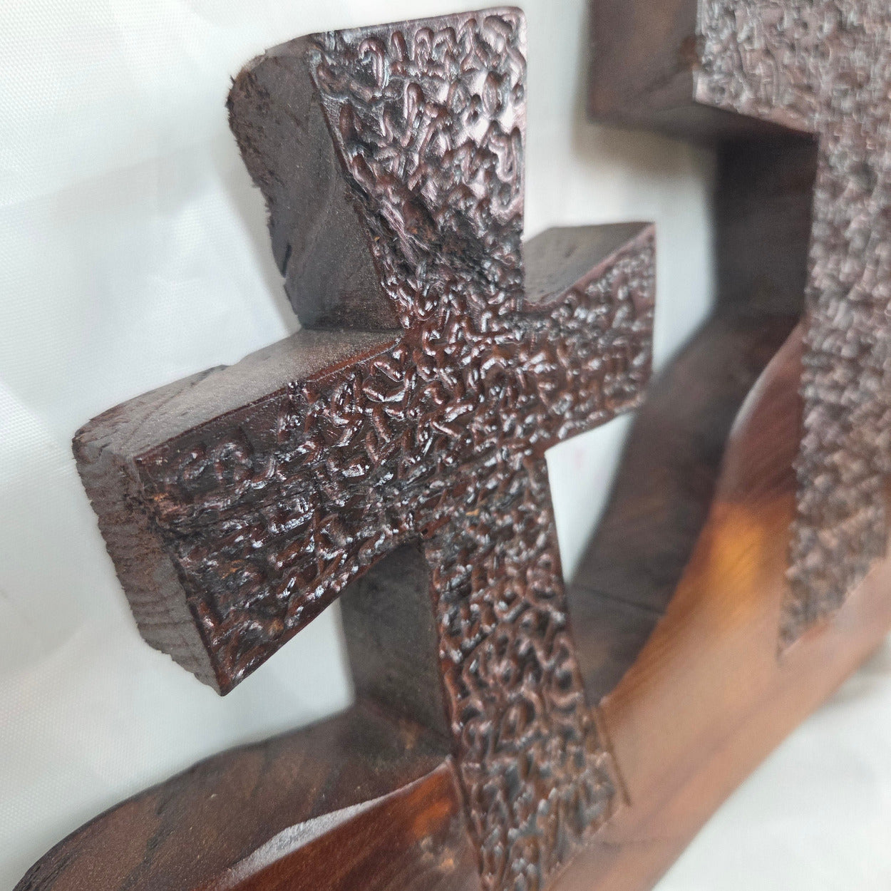 A Bois D'Arc decorative wall plaque featuring three stylized Christian crosses cut from a single slab, hand carved with burned finish sho sugi ban with natural grain 