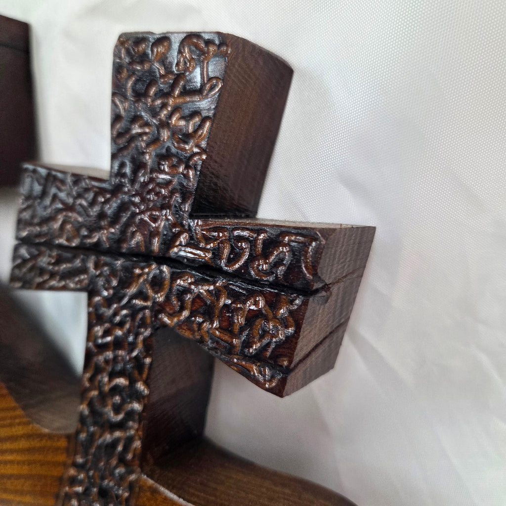 A Bois D'Arc decorative wall plaque featuring three stylized Christian crosses cut from a single slab, hand carved with burned finish sho sugi ban with natural grain 