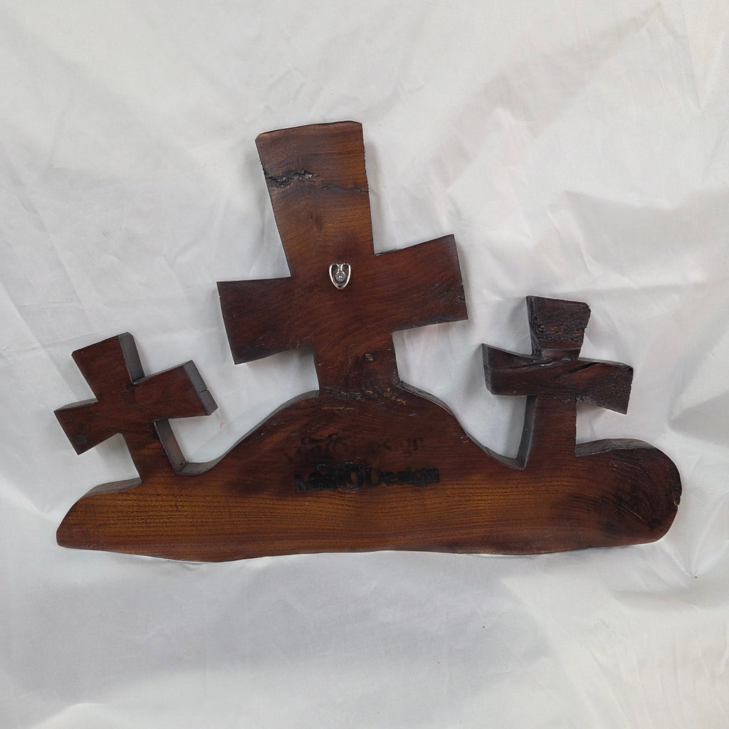 A Bois D'Arc decorative wall plaque featuring three stylized Christian crosses cut from a single slab, hand carved with burned finish sho sugi ban with natural grain 