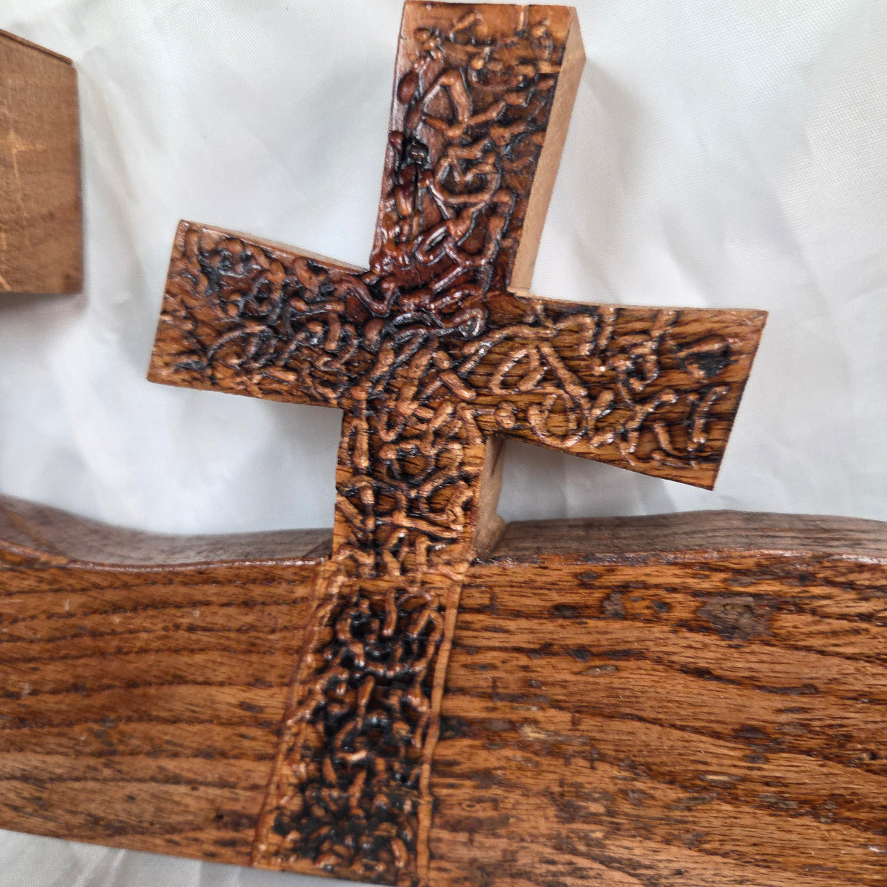 A white oak decorative wall plaque featuring three stylized Christian crosses cut from a single slab, hand carved with burned finish sho sugi ban with natural grain 