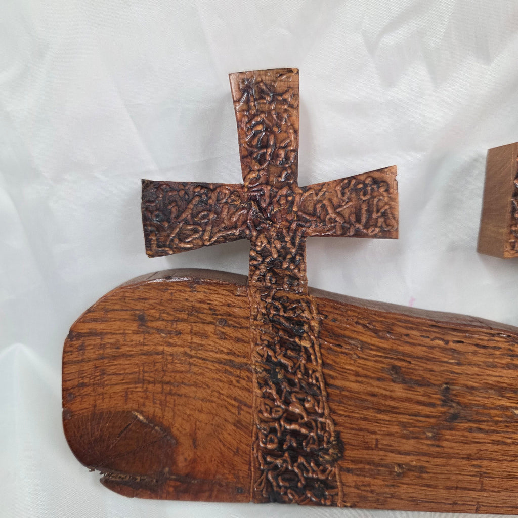 A white oak decorative wall plaque featuring three stylized Christian crosses cut from a single slab, hand carved with burned finish sho sugi ban with natural grain 