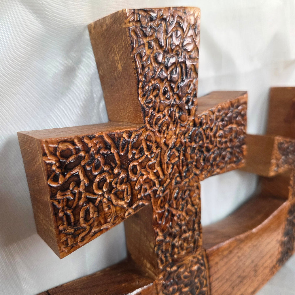 A white oak decorative wall plaque featuring three stylized Christian crosses cut from a single slab, hand carved with burned finish sho sugi ban with natural grain 