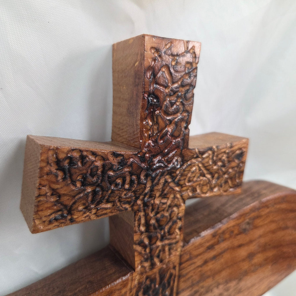A white oak decorative wall plaque featuring three stylized Christian crosses cut from a single slab, hand carved with burned finish sho sugi ban with natural grain 