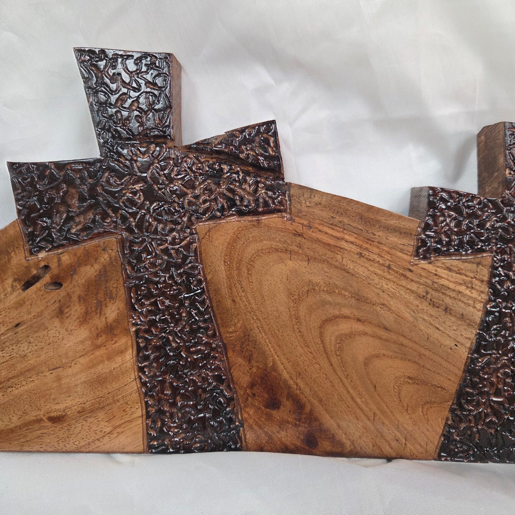 A Pecan decorative wall plaque featuring three stylized Christian crosses cut from a single slab, hand carved with burned finish sho sugi ban with natural grain 