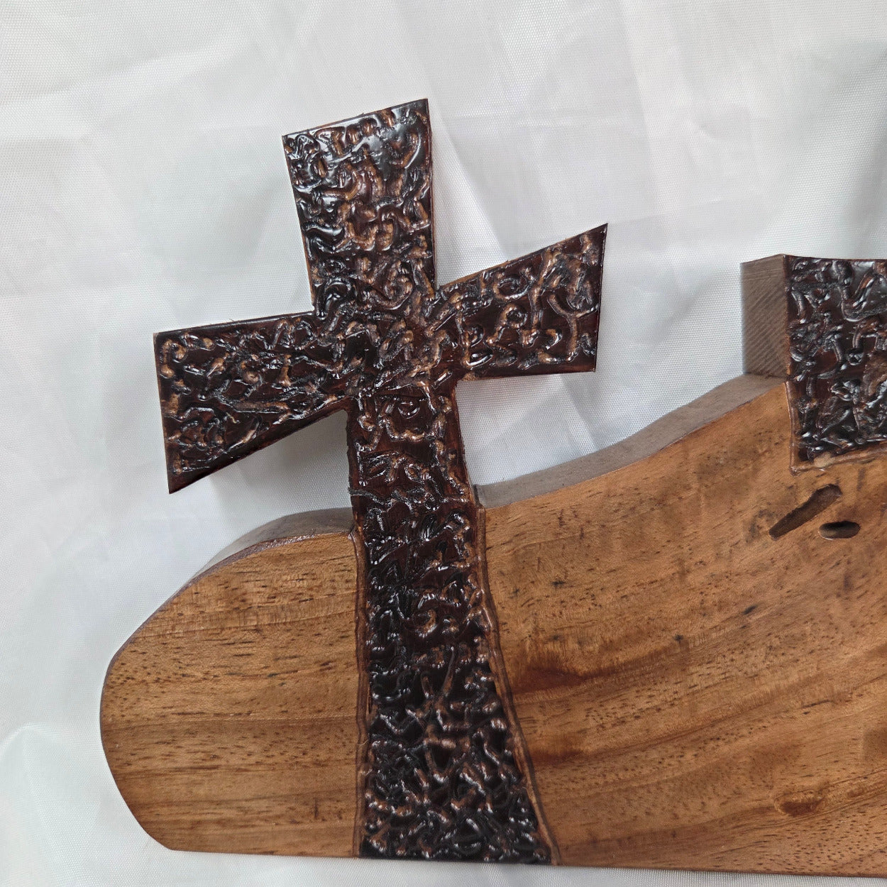 A Pecan decorative wall plaque featuring three stylized Christian crosses cut from a single slab, hand carved with burned finish sho sugi ban with natural grain 