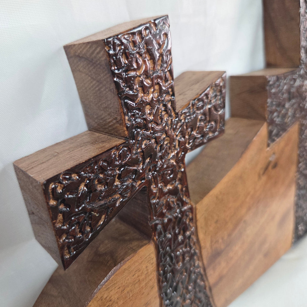 A Pecan decorative wall plaque featuring three stylized Christian crosses cut from a single slab, hand carved with burned finish sho sugi ban with natural grain 