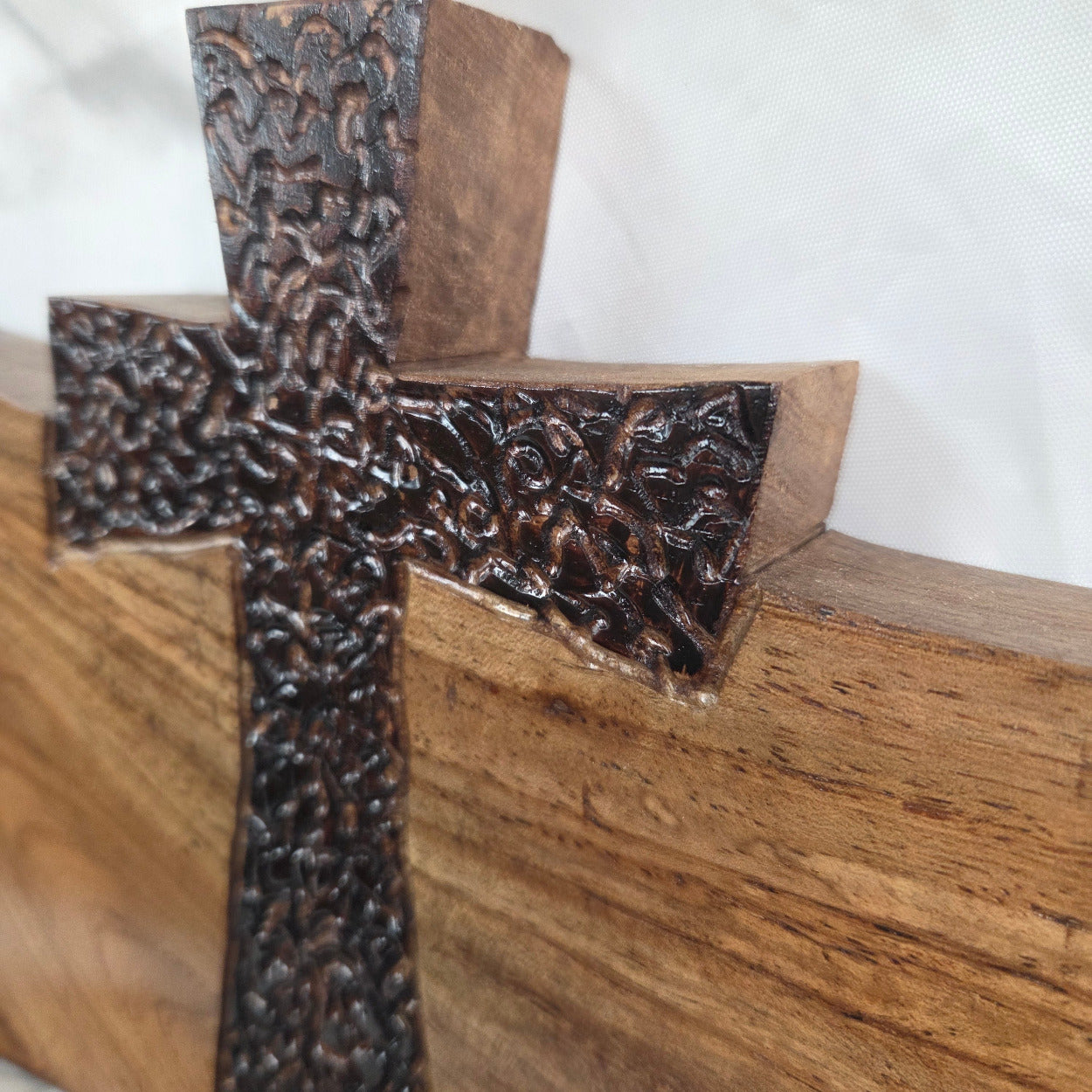 A Pecan decorative wall plaque featuring three stylized Christian crosses cut from a single slab, hand carved with burned finish sho sugi ban with natural grain 