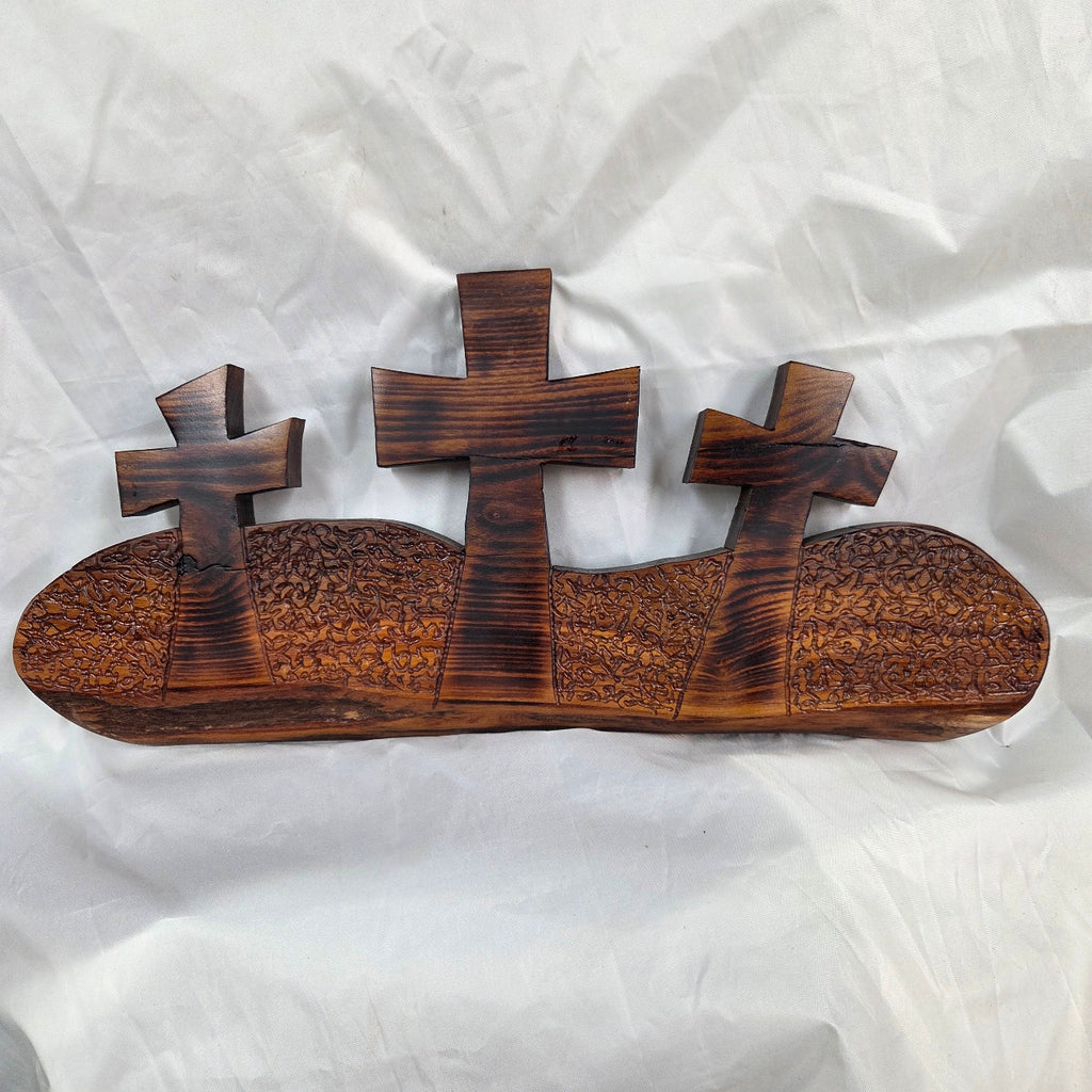 A Bois D'Arc decorative wall plaque featuring three stylized Christian crosses cut from a single slab, hand carved with burned finish sho sugi ban