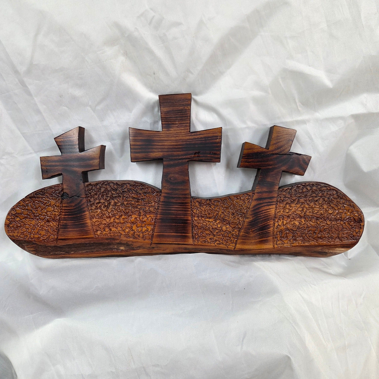 A Bois D'Arc decorative wall plaque featuring three stylized Christian crosses cut from a single slab, hand carved with burned finish sho sugi ban