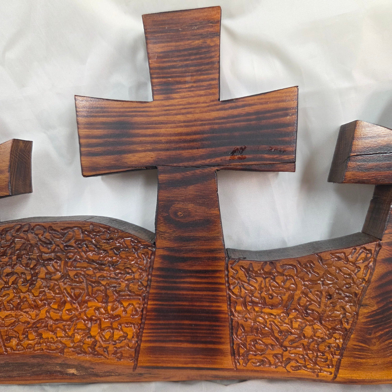A Bois D'Arc decorative wall plaque featuring three stylized Christian crosses cut from a single slab, hand carved with burned finish sho sugi ban