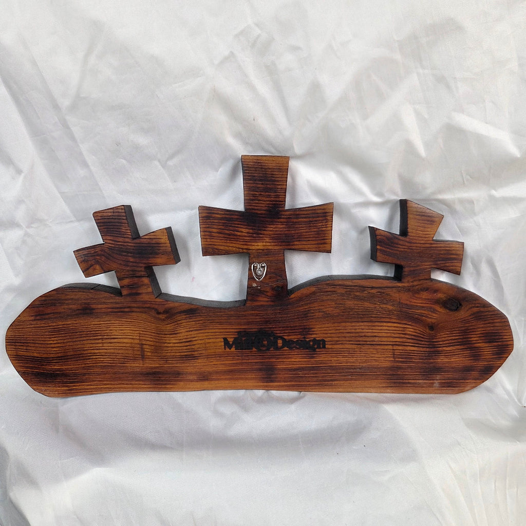 A Bois D'Arc decorative wall plaque featuring three stylized Christian crosses cut from a single slab, hand carved with burned finish sho sugi ban
