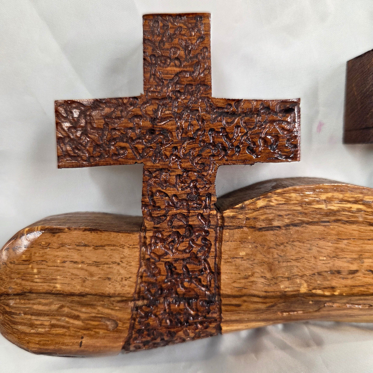 A white oak decorative wall plaque featuring three stylized Christian crosses cut from a single slab, hand carved with dark brown stained crosses and natural color base