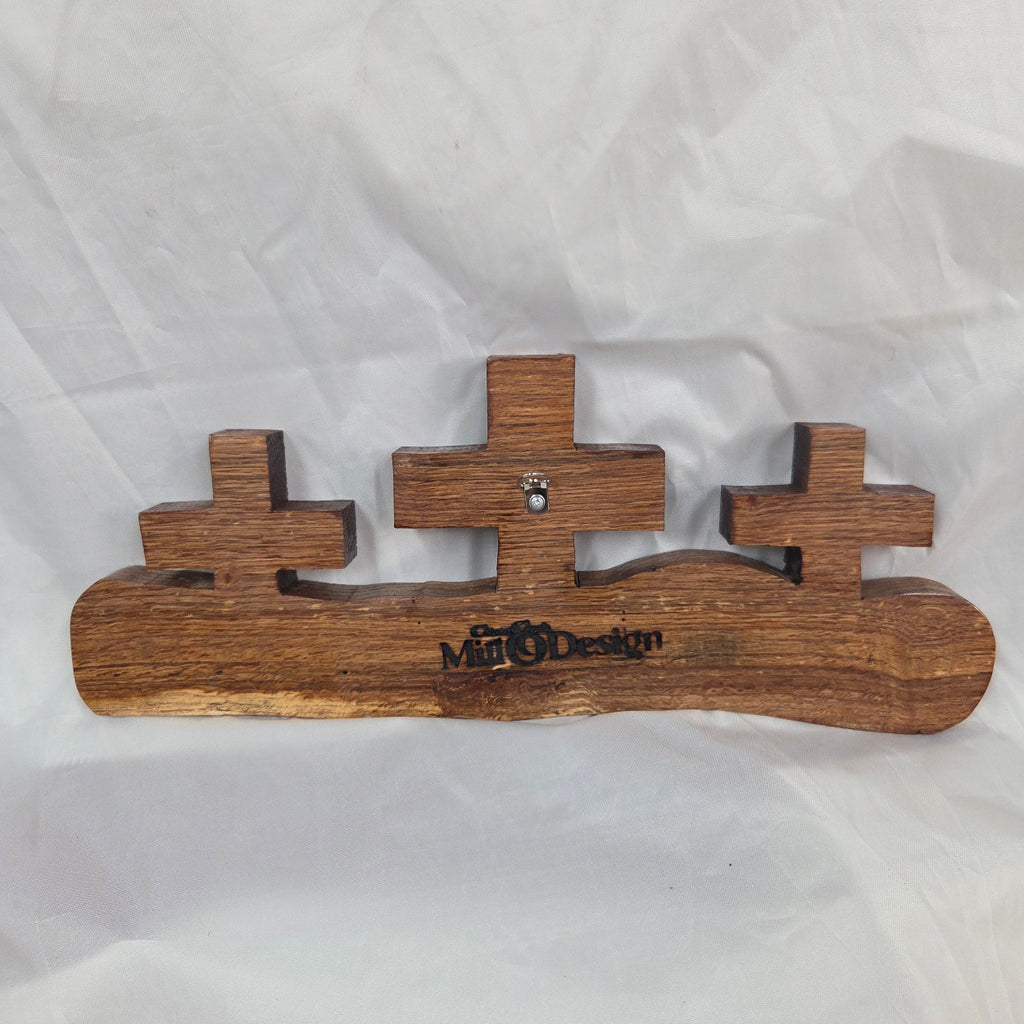 A white oak decorative wall plaque featuring three stylized Christian crosses cut from a single slab, hand carved with dark brown stained crosses and natural color base