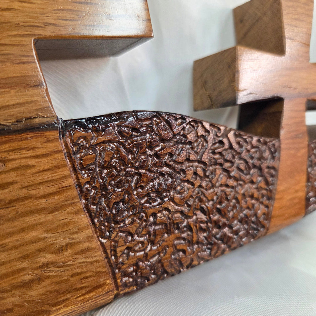A white oak decorative wall plaque featuring three stylized Christian crosses cut from a single slab, hand carved with dark brown wooden base, 