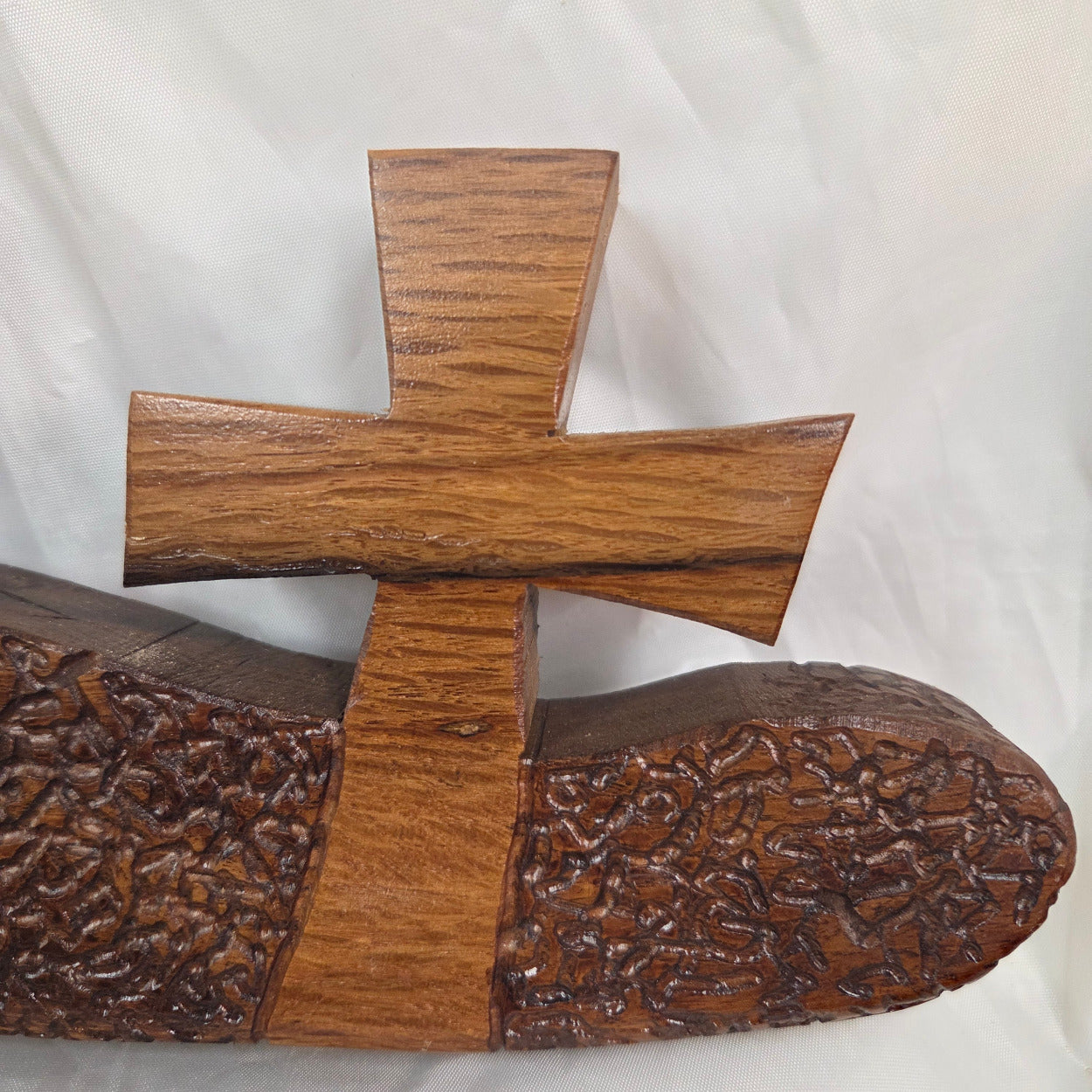 A white oak decorative wall plaque featuring three stylized Christian crosses cut from a single slab, hand carved with dark brown wooden base, 